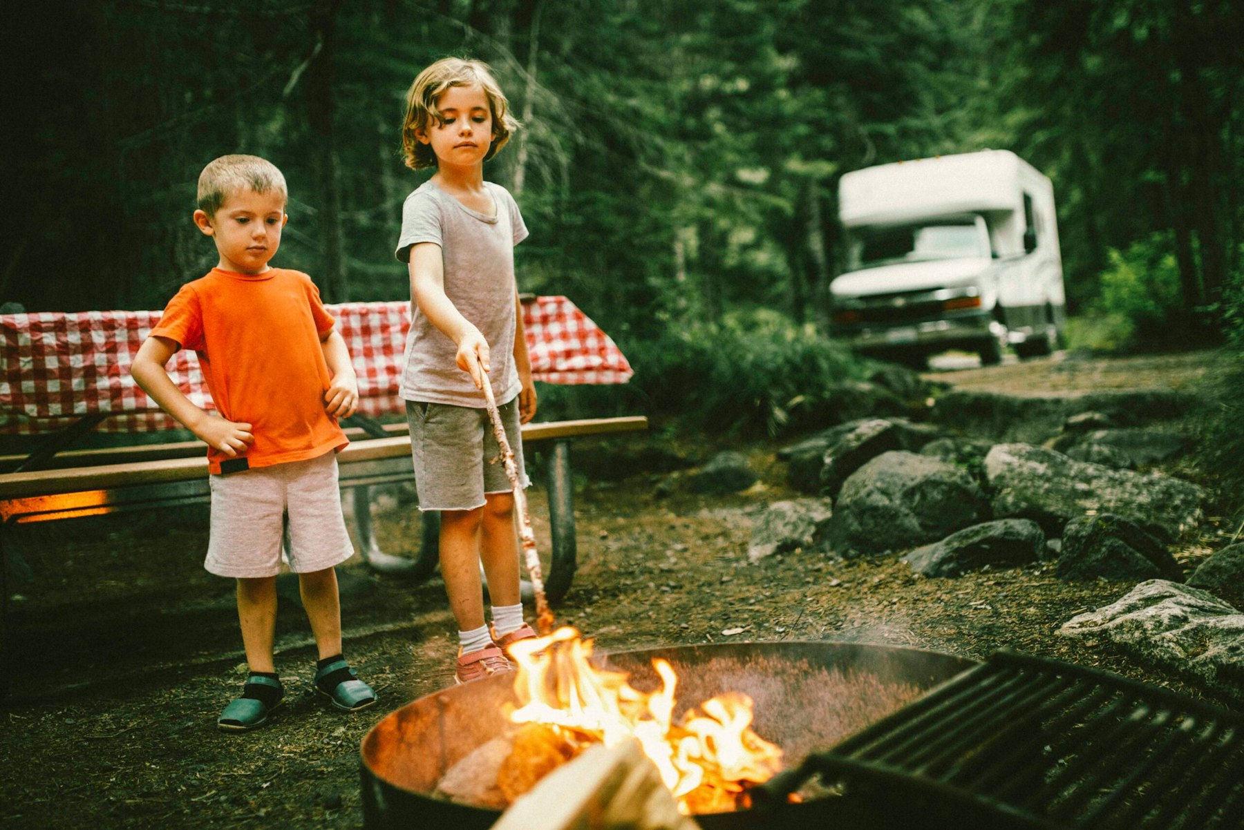 Father and kids around a campfire in the forest
