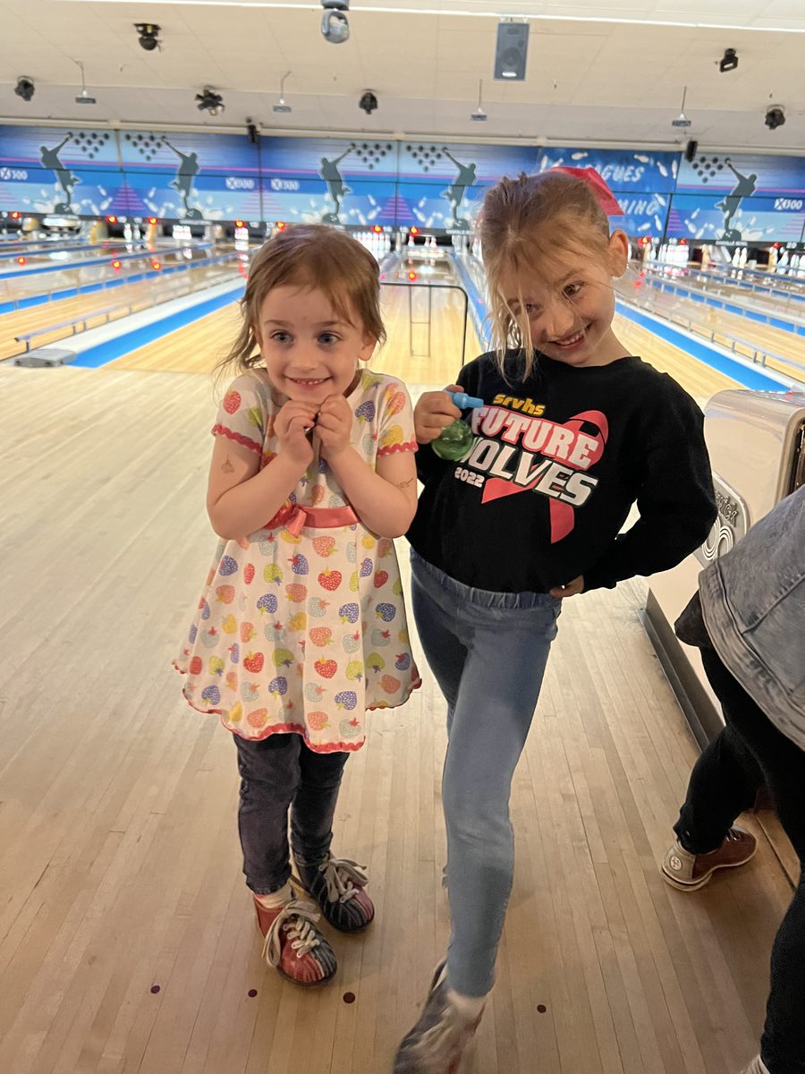 Two girls posing together at the bowling alley