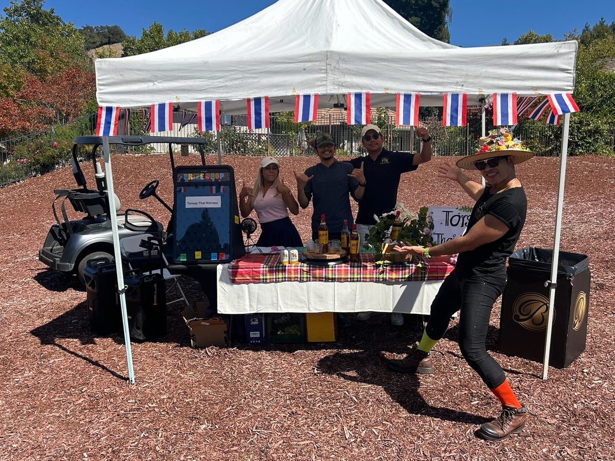 Torsap Thai Kitchen sponsor tent with team posing at the golf tournament