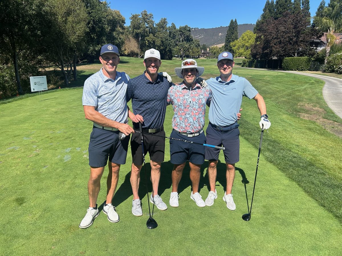 Foursome with sponsor signage on the tee box