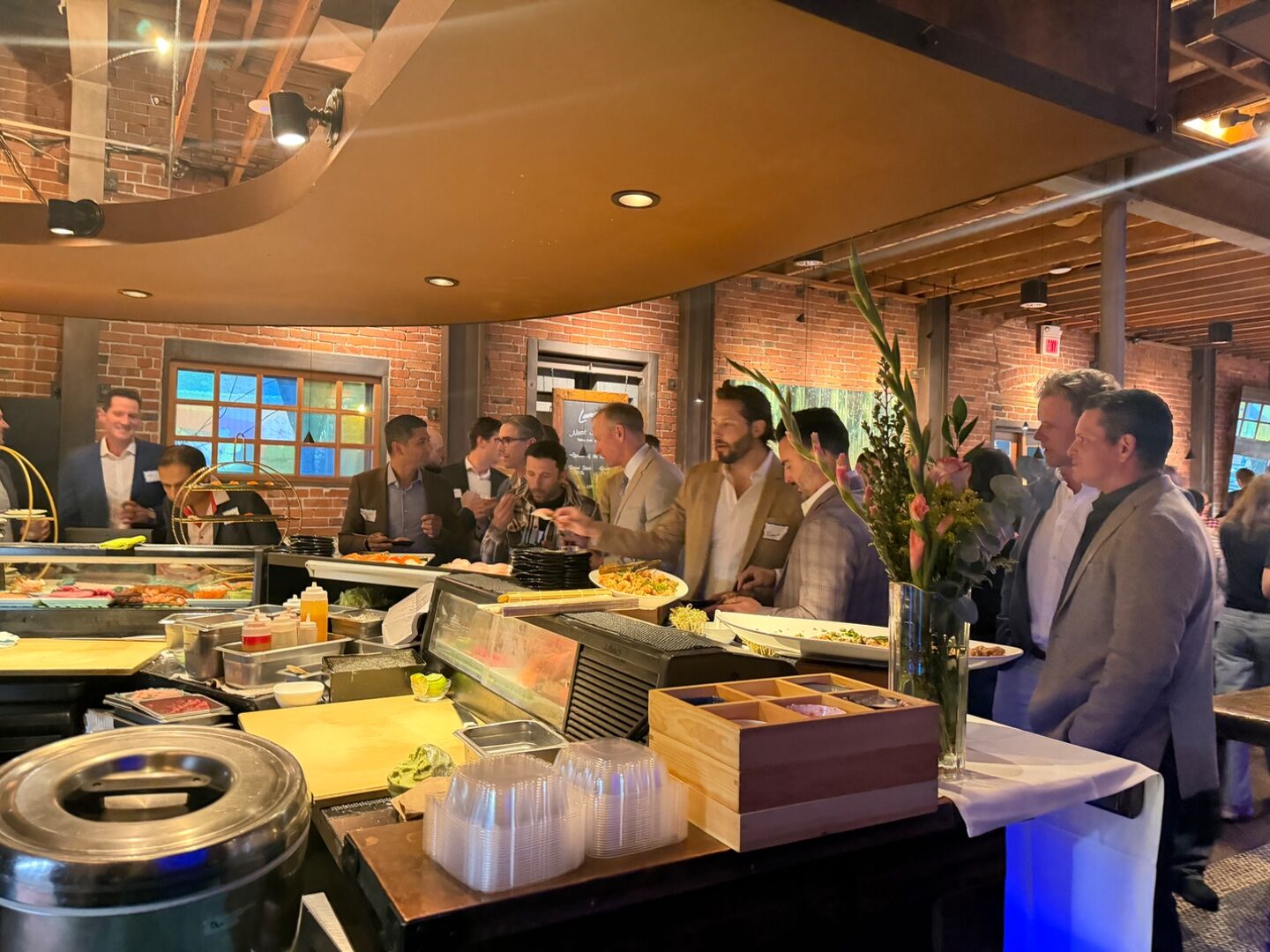 Bulldog Dads chatting near the Sasa sushi bar before dinner service