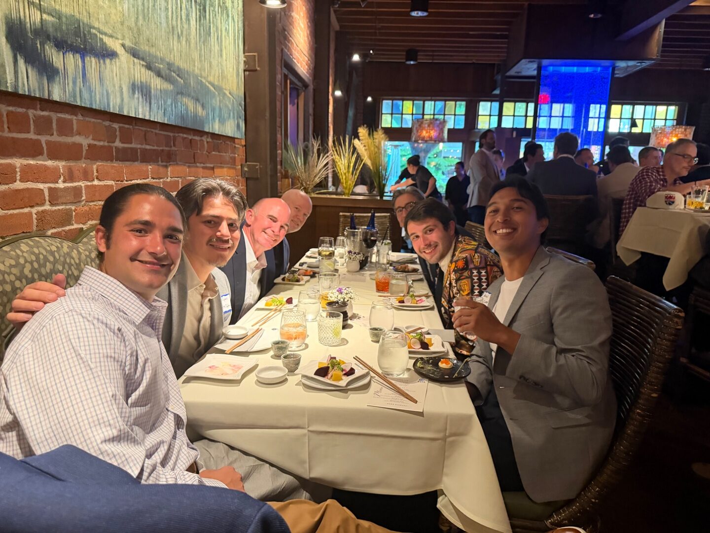 Group of dads smiling around a Sasa dinner table during TLEg 2