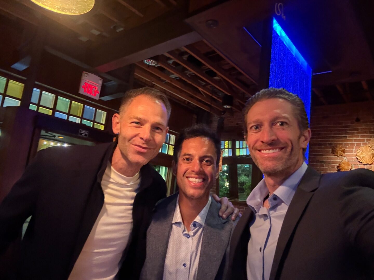 Three Bulldog Dads posing for a TLEg 2 selfie at the bar