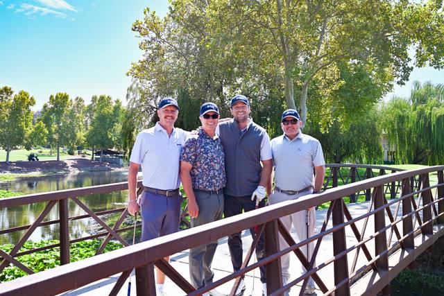 Foursome on the bridge at the 2026 SIS Golf Classic